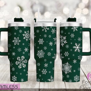 Könnte beinhalten: Ein grüner Edelstahlbecher mit einem weißen Schneeflockenmuster. Der Becher hat einen Deckel und einen Griff. Der Becher ist ein nahtloses Design.