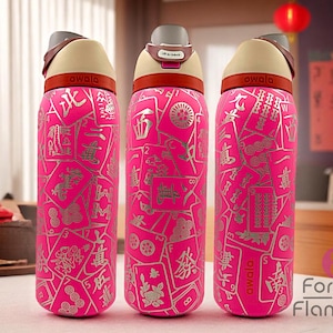 May include: Three pink Owala water bottles with a silver Mahjong tile design. Each bottle has a tan lid, a brown handle, and the word "owala" printed on the bottle. The bottles are on a table with a red teapot.