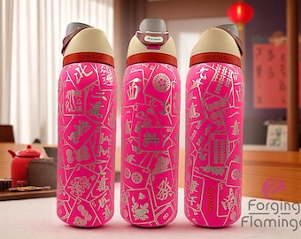 May include: Three pink Owala water bottles with a silver Mahjong tile design. Each bottle has a tan lid, a brown handle, and the word "owala" printed on the bottle. The bottles are on a table with a red teapot.