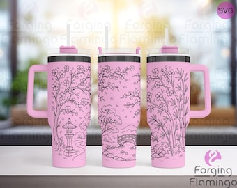 May include: Pink insulated tumbler with a handle, featuring a black line art design of a Japanese garden with cherry blossoms, a bridge, and a pagoda. Includes a clear lid and a reusable straw.