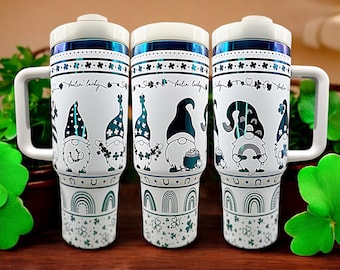 May include: Three white stainless steel travel mugs with a blue and green design featuring gnomes with shamrocks and the text "feelin' lucky".
