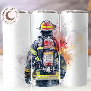 Puede incluir: Un vaso blanco con una ilustración de acuarela de un bombero con equipo completo, incluyendo casco y tanque de oxígeno. El diseño incorpora vibrantes salpicaduras de rojo, amarillo y negro. Se incluye el texto "20 Free Designs".