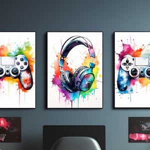 Pode incluir: Três pinturas de aquarela coloridas em tela. As pinturas da esquerda e da direita apresentam um controle de videogame branco com respingos de aquarela coloridos. A pintura do meio apresenta fones de ouvido pretos com respingos de aquarela coloridos.