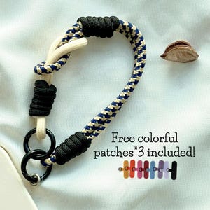 Pulsera para teléfono hecha a mano con cuerda bitono en blanco, azul y camuflaje negro vibrante. Correa universal para teléfono. Ideal como abalorio para bolso. El mejor regalo festivo.