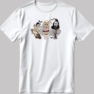 Könnte beinhalten: Weißes T-Shirt mit einem Halloween-Motiv. Das Design zeigt drei stilisierte Eiscreme-Leckereien, die jeweils einen Horrorfilmcharakter darstellen: eine Mumie, Jason Voorhees und Ghostface. Fledermäuse und Spinnweben vervollständigen das gruselige Thema.