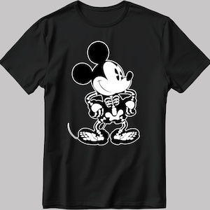 K&ouml;nnte beinhalten: Schwarzes T-Shirt mit einem wei&szlig;en Motiv von Mickey Mouse als Skelett. Mickey Mouse l&auml;chelt und hat die H&auml;nde in die H&uuml;ften gest&uuml;tzt.