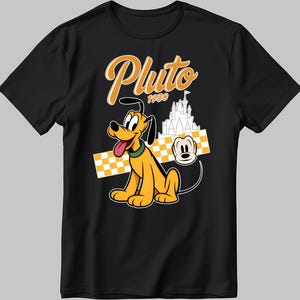 Puede incluir: Camiseta negra con un diseño de Pluto. El diseño incluye a Pluto, el texto "Pluto 1930", un castillo y una cabeza de Mickey Mouse. Pluto es amarillo con un collar verde y su lengua está fuera. El fondo tiene un patrón de cuadros amarillos y blancos.