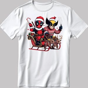 Puede incluir: Camiseta blanca con dise&ntilde;o navide&ntilde;o. Deadpool y Wolverine, con gorros de Pap&aacute; Noel, montados en un trineo tirado por renos. Deadpool sostiene un bast&oacute;n de caramelo. Festivo y divertido.