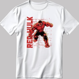 May include: White t-shirt featuring a red illustration of Red Hulk in a dynamic pose against a brick wall background. The text "RED HULK" is printed vertically in red. The shirt is made of a soft, comfortable material.