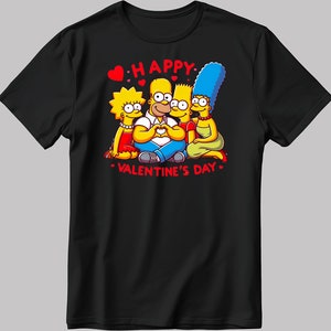 May include: A black t-shirt featuring a graphic of the Simpsons family. Homer, Marge, Lisa, and Maggie are shown in a loving embrace with the text "Happy Valentine's Day".