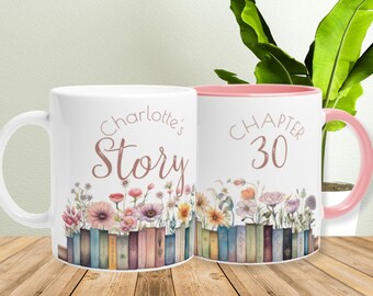 Puede incluir: Dos tazas de cerámica blanca con detalles en rosa. Una taza dice "Charlotte's Story" con un diseño floral y una fila de libros en la parte inferior. La otra taza dice "Chapter 30" con un diseño floral y una fila de libros en la parte inferior.
