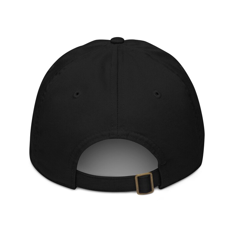 May include: A black baseball cap with a curved brim. The back of the cap features an adjustable strap with a metal buckle. The cap is made of a solid, dark fabric.