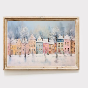 May include: A framed watercolor painting of a row of colorful houses with snow-covered roofs. The houses are lined up in a row, with trees in front of them. The sky is a light blue, and the snow is white.