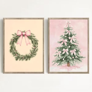 May include: Two framed watercolour prints. One shows a Christmas wreath with a pink bow on a cream background. The other depicts a Christmas tree adorned with pink bows and baubles against a pink backdrop. Both are in wooden frames.