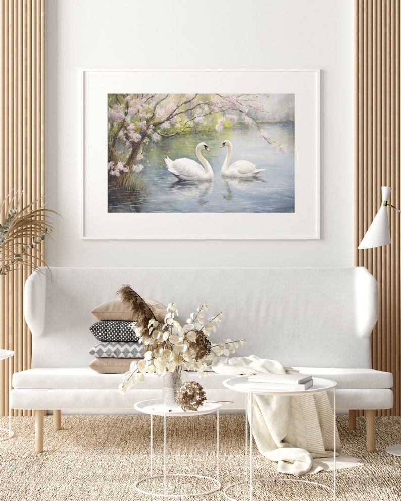 May include: A framed painting of two white swans swimming in a lake with a blooming tree in the background.