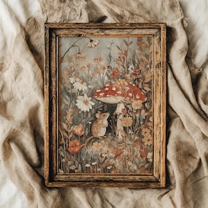 Op de afbeelding: Een ingelijste kunstdruk met een grillige illustratie van een muis in een veld met wilde bloemen en een roodkappige paddenstoel. Het kunstwerk heeft een vintage esthetiek met warme, aardse tinten en een rustieke houten lijst.
