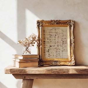 Puede incluir: Una tarjeta de biblioteca antigua con fechas selladas, enmarcada en un marco dorado ornamentado. La tarjeta muestra columnas de fechas y el texto DATE DUE en la parte superior. Junto al marco hay un peque&ntilde;o jarr&oacute;n de cristal con flores secas.