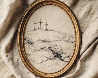 May include: An oval framed artwork featuring a pen and ink drawing of three crosses atop a hill. The frame is gold-toned, and the artwork is set against a neutral-colored fabric background. The drawing style is detailed and illustrative.