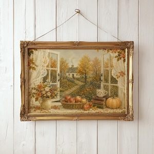 Puede incluir: Un cuadro de paisaje rectangular en un marco dorado ornamentado, que muestra la vista desde una ventana abierta hacia una casa de campo en otoño, con una cesta de manzanas, libros, una taza y una calabaza en el alféizar, colgado de un alambre.