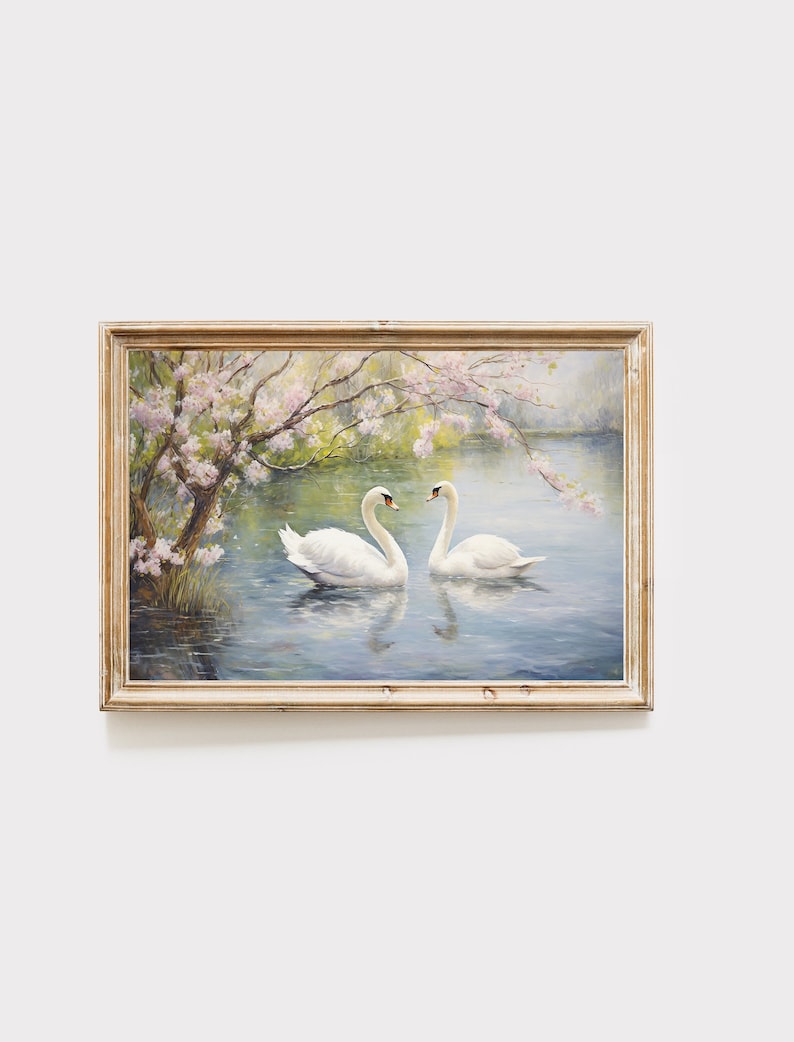 May include: A framed painting of two white swans swimming in a lake with a tree with pink blossoms in the background.