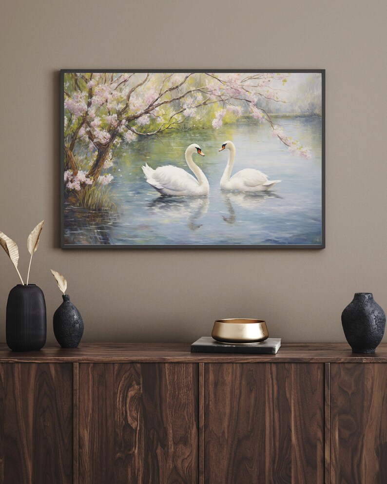 May include: A painting of two white swans swimming in a lake with a blooming tree in the background. The swans are facing each other and the water is a light blue color.