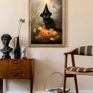 May include: A black cat wearing a witch's hat sits on top of a carved jack-o'-lantern pumpkin. The cat has green eyes and is surrounded by autumn leaves.