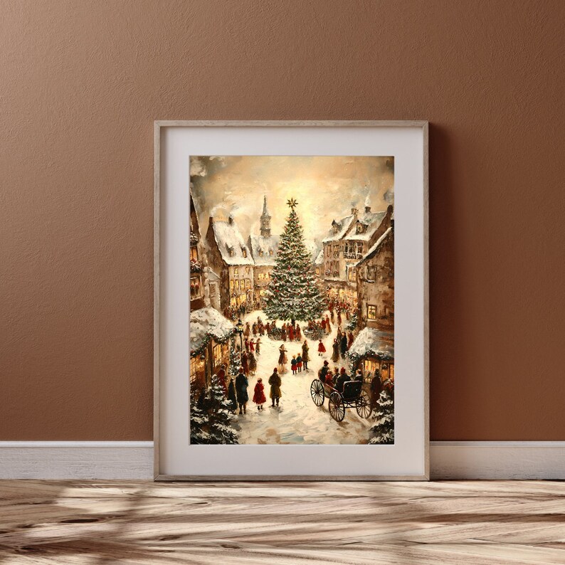 May include: Framed print of a winter scene depicting a snowy town square with a large Christmas tree. Buildings with snow-covered roofs surround the square, and figures of people and a horse-drawn carriage are visible. The artwork has a warm, inviting color palette.