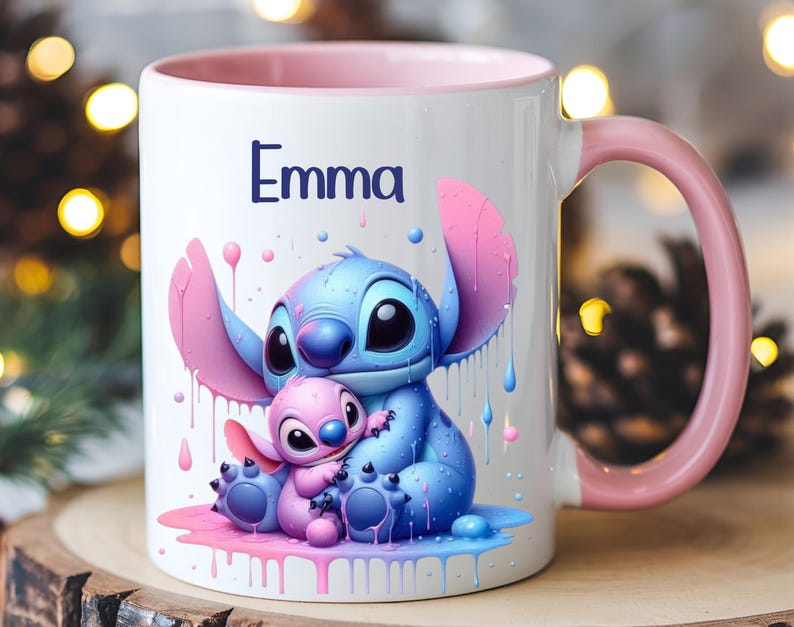 K&ouml;nnte beinhalten: Eine wei&szlig;e Keramiktasse mit rosafarbenem Rand und Henkel. Die Tasse zeigt eine farbenfrohe Illustration von Stitch und Angel aus dem Disney-Film Lilo & Stitch. Der Text "Emma" ist auf die Tasse gedruckt.