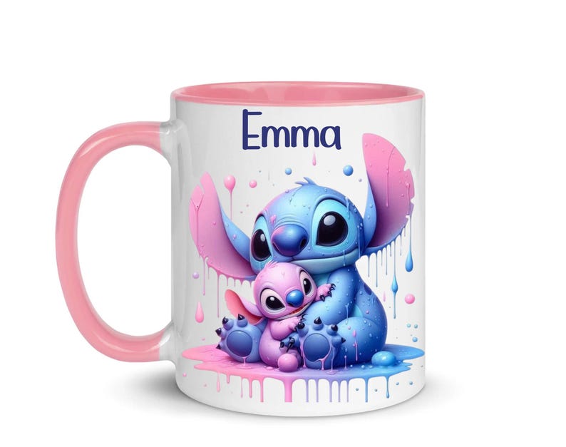 K&ouml;nnte beinhalten: Eine wei&szlig;e Keramiktasse mit rosafarbenem Rand und Henkel. Die Tasse zeigt eine farbenfrohe Illustration von Stitch und Angel aus dem Disney-Film Lilo & Stitch. Der Text "Emma" ist auf die Tasse gedruckt.