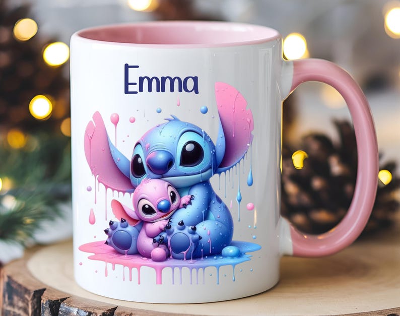 K&ouml;nnte beinhalten: Eine wei&szlig;e Keramiktasse mit rosafarbenem Rand und Henkel. Die Tasse zeigt eine farbenfrohe Illustration von Stitch und Angel aus dem Disney-Film Lilo & Stitch. Der Text "Emma" ist auf die Tasse gedruckt.