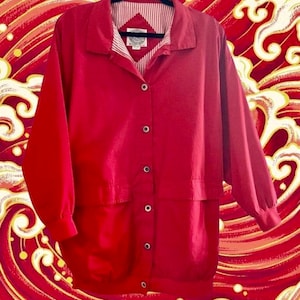 May include: A red button-up jacket with a white and red striped lining. The jacket has two large pockets on the front and a button closure.