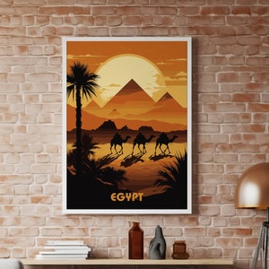 Op de afbeelding: Een vintage reisposter met een zonsondergangscène van de piramides in Egypte. De poster toont een silhouet van kamelen die door de woestijn lopen met palmbomen op de voorgrond. De tekst "EGYPT" staat onderaan de poster.