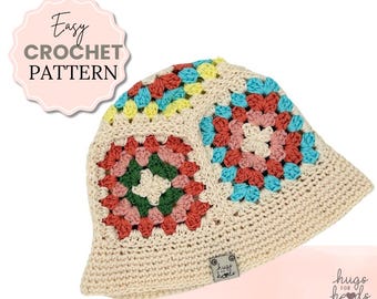 May include: A crocheted hat with a granny square pattern in shades of pink, blue, green, and yellow. The hat is made with a cream-colored yarn and has a brim. The hat has a small label that says "hugs for hearts".