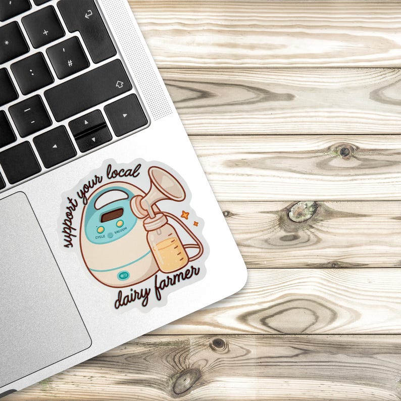 May include: A sticker depicting a cartoon breast pump and bottle, with the words "support your local dairy farmer". The pump is white and teal, and the bottle is filled with a yellow liquid. The sticker is on a laptop.