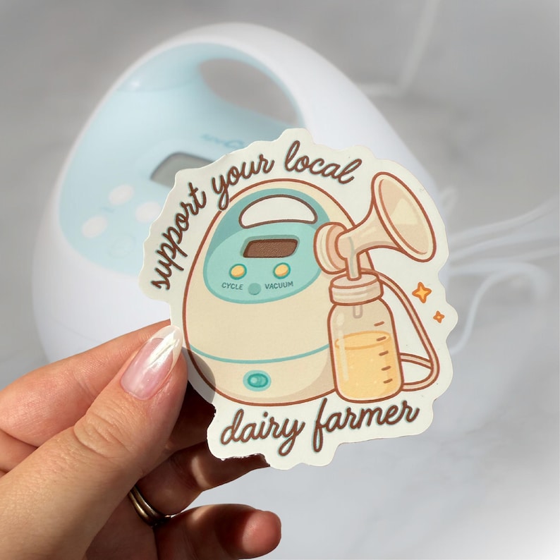 May include: A cream-coloured sticker featuring the text "support your local dairy farmer" and a breast pump illustration. The sticker has teal and brown accents. A breast pump is visible in the background.