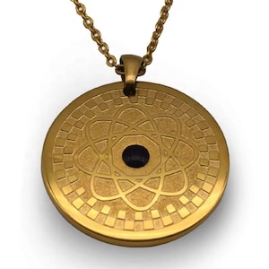 May include: A gold-coloured pendant necklace. The circular pendant has a geometric design and a central black stone. The chain and pendant are the same gold colour.