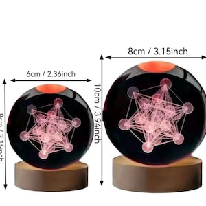 May include: Two spherical glass ornaments on cylindrical wooden bases, each containing a pink geometric star pattern. The smaller sphere measures 2.36 inches wide by 3.15 inches high, and the larger sphere measures 3.15 inches wide by 3.94 inches high.