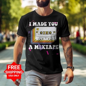 May include: A black t-shirt with the text "I made you a mixtape" and a retro cassette tape graphic. The graphic is in rainbow colors and has a white background.