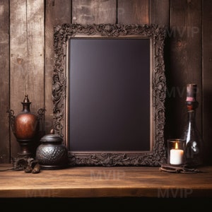 May include: A dark wood framed chalkboard with ornate carvings, a small metal container with a lid, a metal vase with a lid, a clear glass bottle with a cork stopper, and a lit candle on a wooden table.
