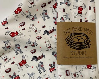 Könnte beinhalten: Ein 8er-Pack wiederverwendbarer papierloser Handtücher mit weißem Hintergrund und einem Muster von Hunden, die rote Bandanas tragen. Die Handtücher sind mit einem braunen Etikett verpackt, auf dem "The Byrd Nest Studio 8 Pack - Reusable Paperless Towels" steht.
