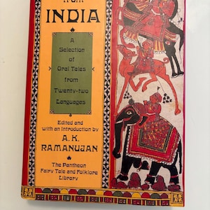 May include: A vintage book titled "Folktales from India" with a vibrant cover. The cover features illustrations of figures on animals in red, black, and tan. The book's title and author's name are prominently displayed in bold text.