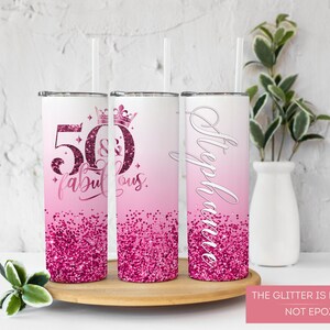 May include: Three pink and white stainless steel tumblers with glitter accents. The tumblers feature the text "50 & Fabulous" and "Stephanie".