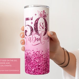 May include: Pink and white stainless steel tumbler with a glitter design and the text "50 & Fabulous" with a crown above the 50.