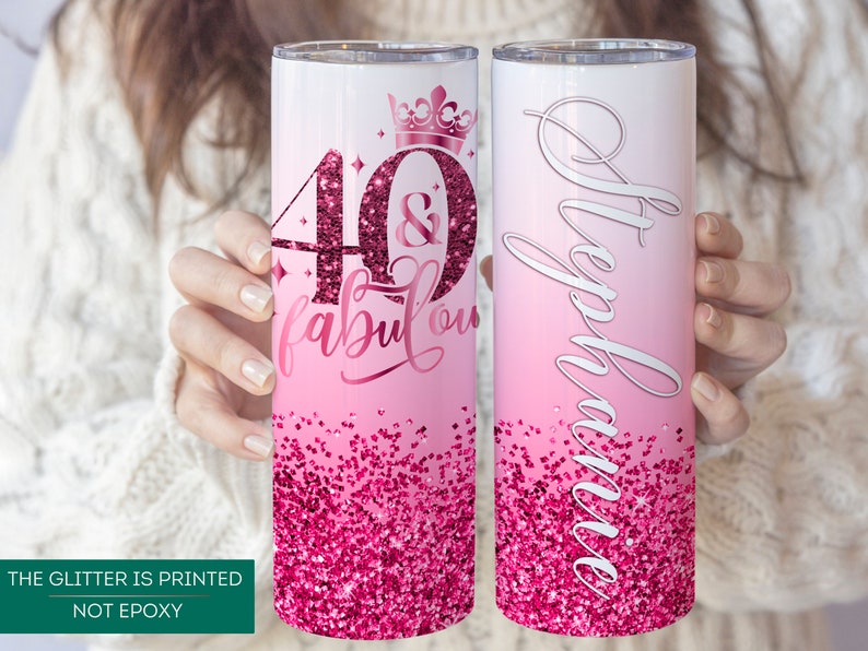 May include: Two pink and white stainless steel tumblers with a glitter design. One tumbler has the text "40 & fabulous" with a crown on top. The other tumbler has the name "Stephanie" written on it.