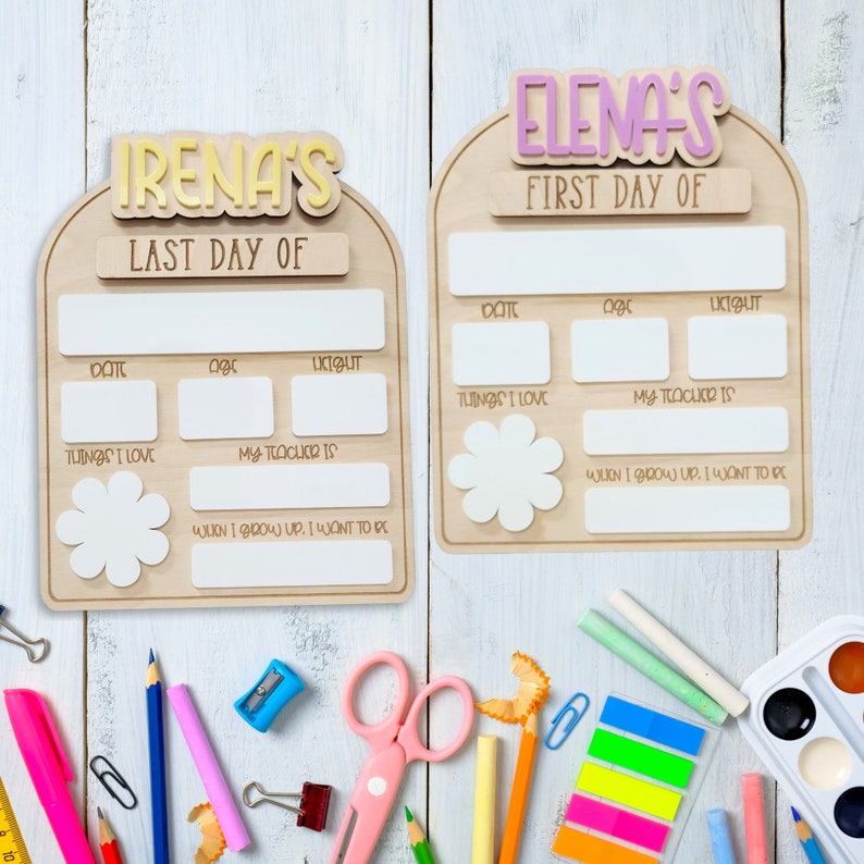May include: Two wooden signs with blank spaces for writing. The signs are decorated with the words "Irena's Last Day of" and "Elena's First Day of" in colorful letters. The signs are perfect for celebrating the first or last day of school.