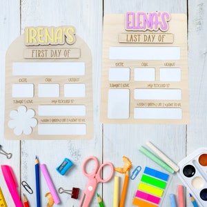 May include: Two wooden signs with blank spaces for writing. The signs are decorated with the words "Irena's First Day Of" and "Elena's Last Day Of". The signs are perfect for capturing memories of a child's first and last day of school.