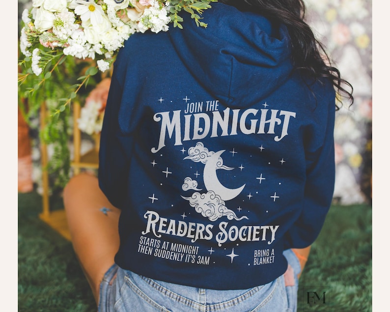 Może przedstawiać: Bordowy sweter z kapturem z białym nadrukiem, na kt&oacute;rym widnieje napis "Join the Midnight Readers Society". Nadruk zawiera r&oacute;wnież p&oacute;łksiężyc i chmury. Tekst pod nadrukiem brzmi "Starts at midnight then suddenly it's 3am. Bring a blanket."