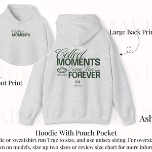 May include: A gray hoodie with a pouch pocket. The front of the hoodie has the text "Collect Moments" printed in black. The back of the hoodie has the text "Collect Moments Enjoy Now and Forever" printed in black. The hoodie is available in the color ash.