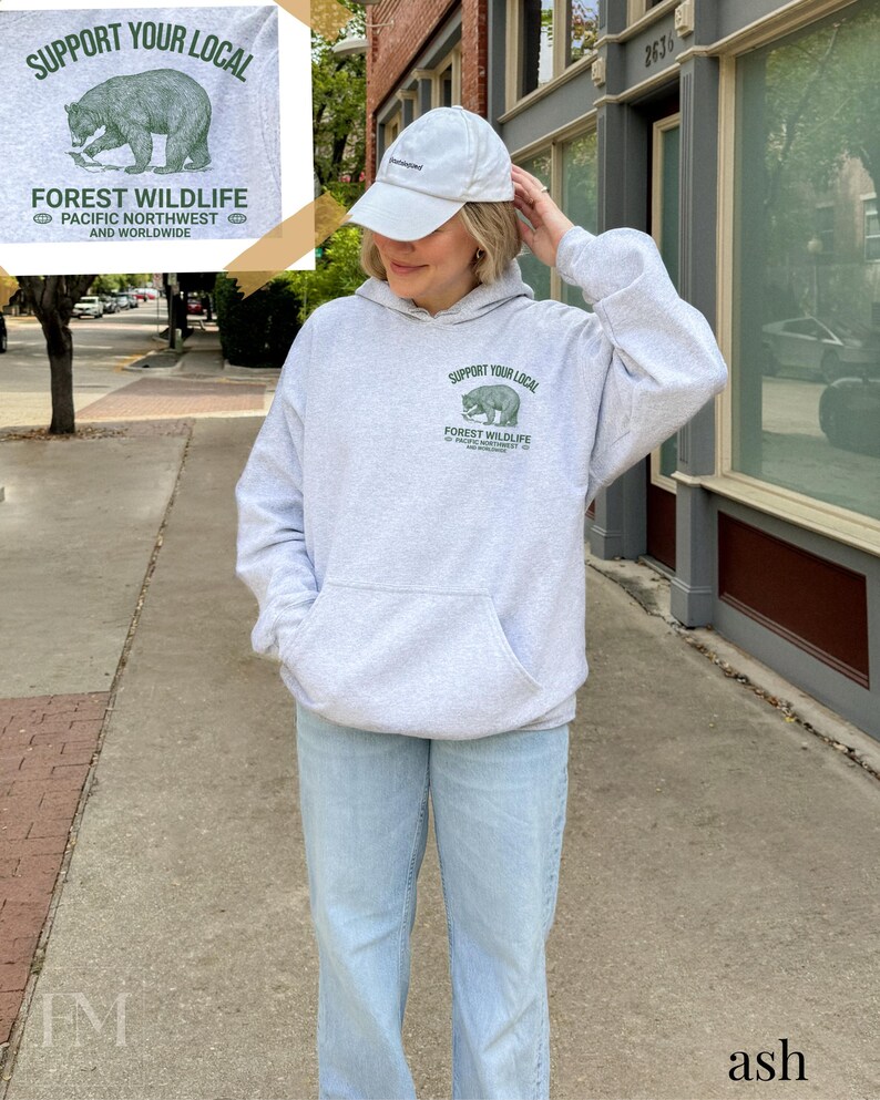 May include: A gray hooded sweatshirt with a green bear graphic and the text "Support Your Local Forest Wildlife Pacific Northwest and Worldwide".