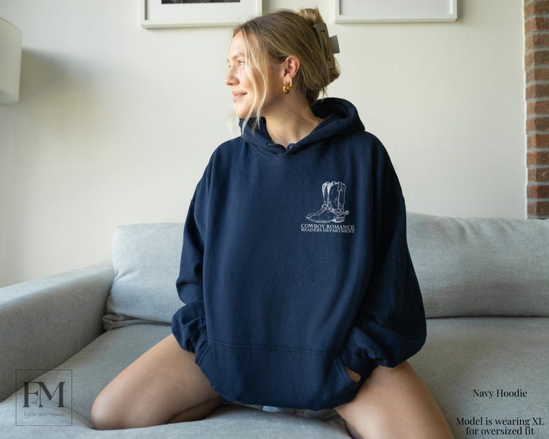 May include: Navy blue hoodie with a white graphic of cowboy boots and the text "Cowboy Romance Registrar Department".